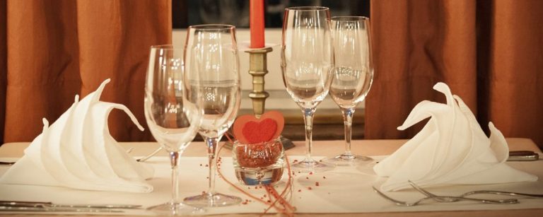 Tischdekoration mit Servietten und Gläsern für romantische Momente – ideal für Paare.