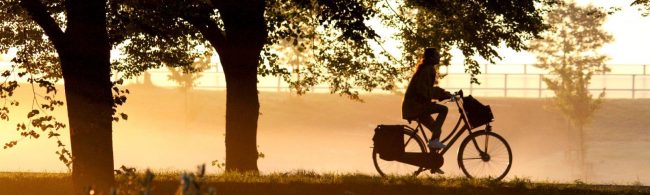Frau radelt bei Sonnenaufgang für Fitness und Wohlbefinden.