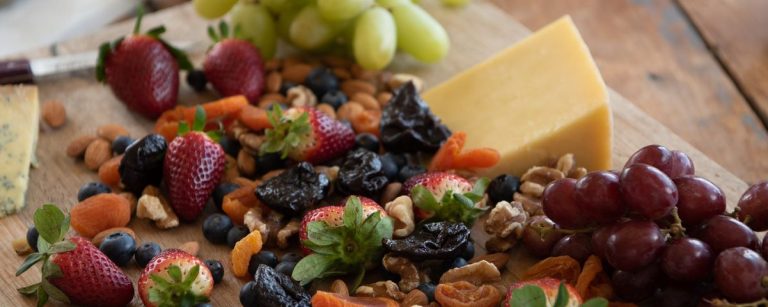 Fitness-Snack-Brett mit Käse, Beeren, Nüssen und Trockenfrüchten.