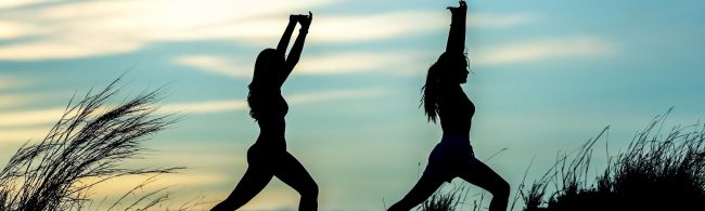Zwei Frauen machen Yoga im Freien, um ihren gesunden Lebensstil zu fördern.