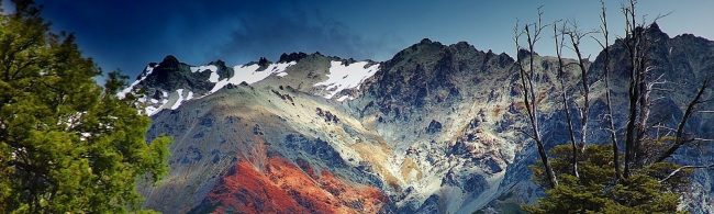 Berglandschaft mit Schnee, rotem Gestein und Bäumen. Ideal für Outdoor-Fitness-Ernährung.
