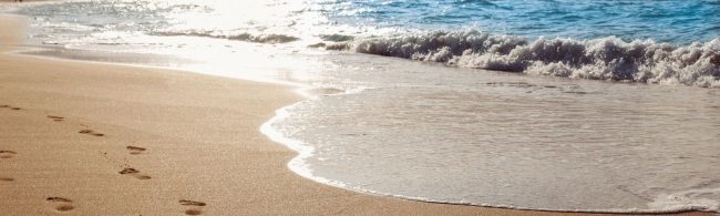 Fußspuren im Sand: ein Symbol für Fitnessziele und gesunde Ernährung.