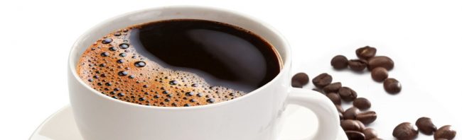Eine Tasse Kaffee mit Schaum und Kaffeebohnen, perfekt für dein Fitness-Ernährungsprogramm.