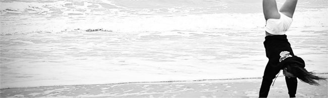 Eine Person macht einen Handstand am Strand, was Fitness und Wohlbefinden symbolisiert.