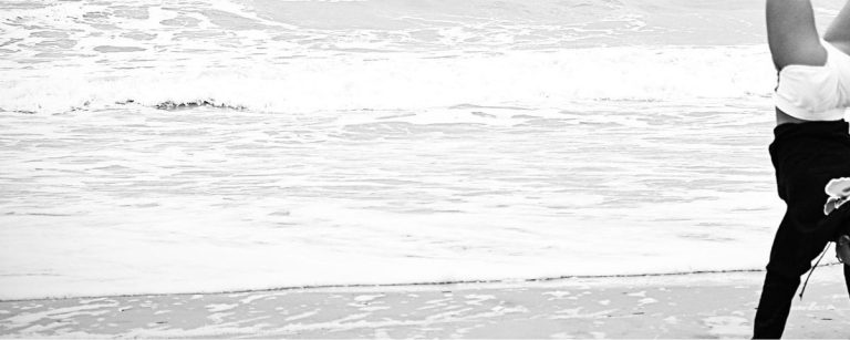 Eine Person macht einen Handstand am Strand, was Fitness und Wohlbefinden symbolisiert.