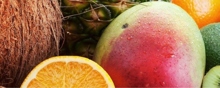 Vielfalt an gesunden Früchten: Kokosnuss, Mango, Ananas, Orange, Avocado, Kiwi für Fitnessernährung.