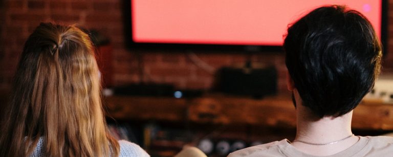 Mann und Frau schauen fern, gesunde Ernährung und Fitness im Fokus.