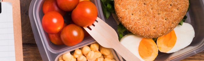 Gesunde Mahlzeit: Tomaten, Kichererbsen, Ei und Vollkornbrot im Bento-Behälter.