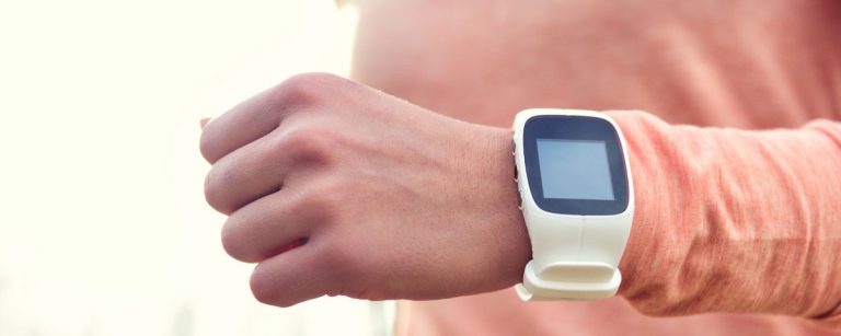 Nahaufnahme einer Person, die ihre Sportuhr überprüft, geeignet für eine Fitness-Ernährungsfirma.