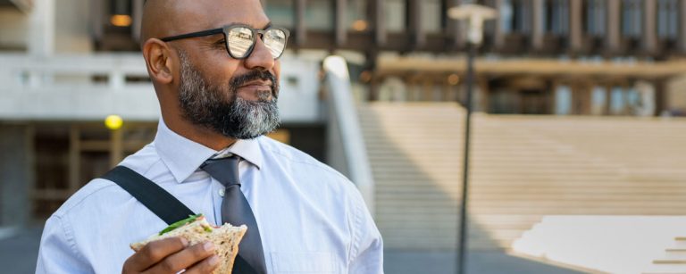 Mann mit Bart isst Sandwich, gesunde Ernährung für Fitness.