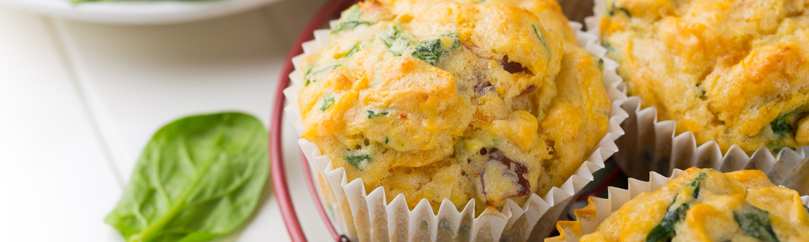 Savory gluten-free veggie muffins with zucchini and carrot cooling on a wire rack, rustic kitchen setting.