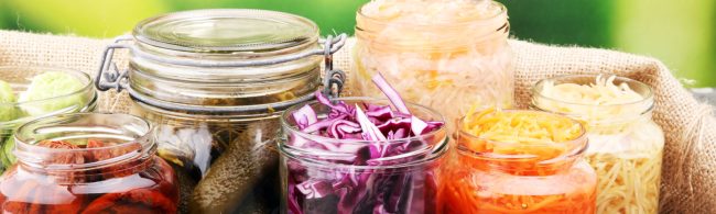 Glasbehälter mit eingelegtem Gemüse und Obst. Fitnessfreundliche, gesunde Lebensmittel.