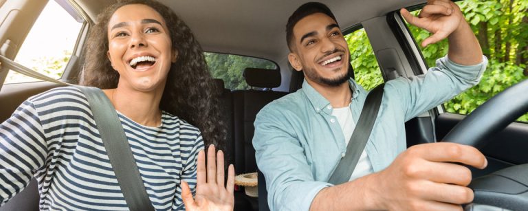 Glückliches Paar im Auto auf dem Weg zu einem gesunden Lebensstil.