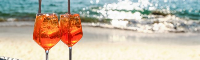 Light Aperol spritz with plenty of ice and an orange slice in a large wine glass