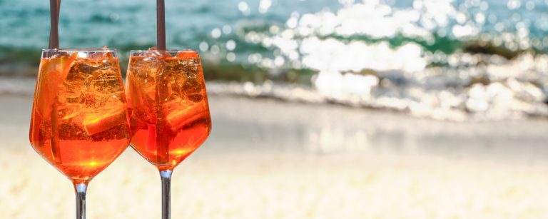 Light Aperol spritz with plenty of ice and an orange slice in a large wine glass