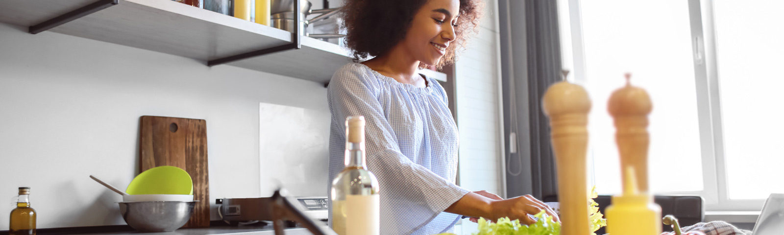 Frau bereitet gesunde Mahlzeit mit frischem Salat zu, ideal für Fitness-Ernährung.