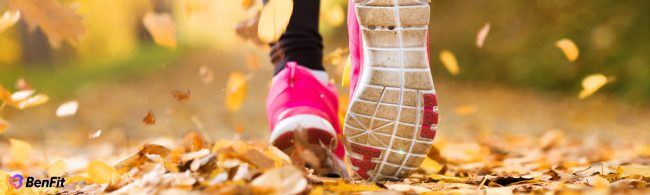 Person walking outdoors with fitness tracker showing daily step goal of 10,000